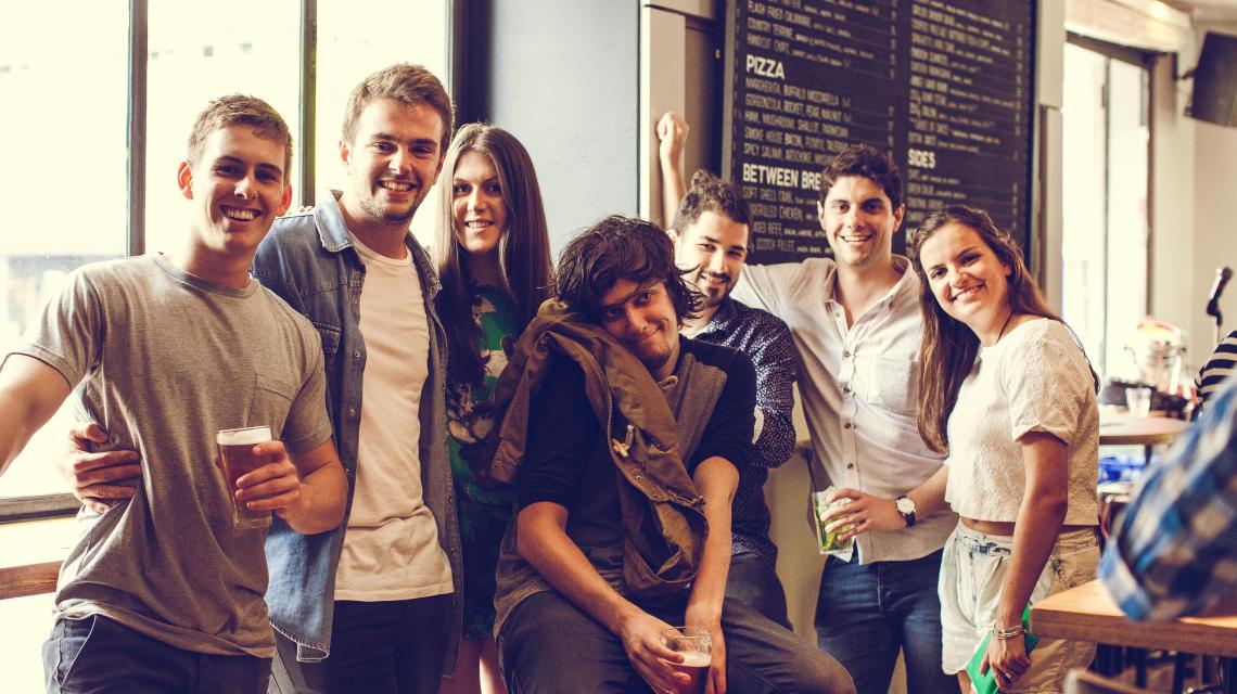 A group of seven people looking at the camera and smiling